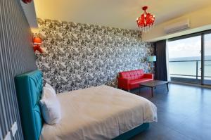 a bedroom with a bed and a red chair at Whitecaps B&B in Yanliau