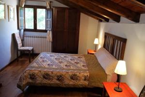 1 dormitorio con 1 cama, 2 mesas y 1 silla en La Colmena, en Navalsaz