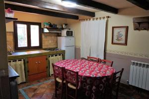 La Colmena في Navalsaz: مطبخ مع طاولة مع قطعة قماش حمراء عليه