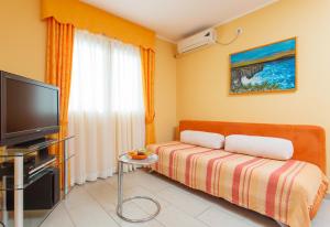 uma sala de estar com um sofá e uma televisão em Djurovic Apartments Montenegro em Kotor