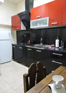 une cuisine avec des armoires noires et une table en bois dans l'établissement Apartment at sunny yard, à Tbilissi