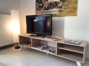 a flat screen tv sitting on a entertainment center at Le Clos des Platanes in Saint-Cyprien