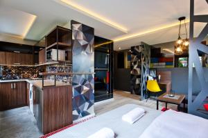 a bedroom with a bed and a kitchen with a bar at Apartament Trójkąty i Kwadraty in Łańcut
