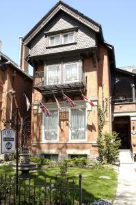 a house with flags on the front of it at Victoria's Mansion Guest House in Toronto