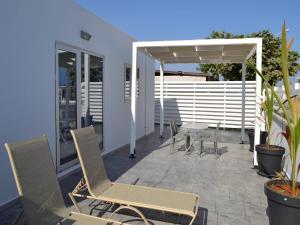 a patio with chairs and an umbrella and a table at Makronissos Beach Studio in Ayia Napa