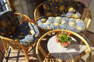a patio with chairs and a table with a pot of flowers at Citadel Residence in Sighişoara