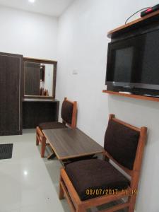 a dining room with a table and chairs and a flat screen tv at Hotel Vrindavan in Fatehpur Sīkri +23 photos