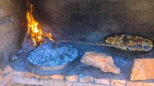 a fire oven with a pot of food and a pan of food at House Antica in Lastovo