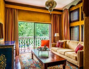 a living room with a couch and a table at Avani Victoria Falls Resort in Livingstone