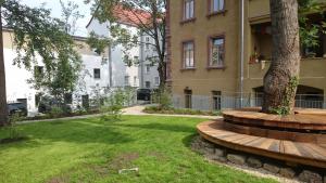 a park in front of a building with a tree at "goethezimmer" - Mini-Ferienwohnungen in der Leibnizallee in Weimar