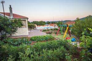 - un jardin avec une aire de jeux dans la cour dans l'établissement Villa Kata, à Vrpolje