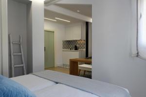 ein Schlafzimmer mit einem Bett und eine Küche im Hintergrund in der Unterkunft LEÓN SUITE Urban Studios in León