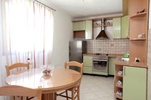 a kitchen with a wooden table and a dining room at Guesthouse Kate in Trogir