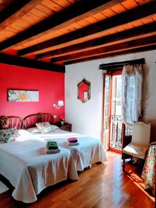 a bedroom with two beds and a red wall at Agroturismo Ondarre in Segura