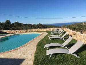 - une rangée de chaises longues blanches à côté de la piscine dans l'établissement Brise Marine, à Bonifacio