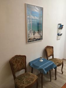 a room with two chairs and a table and a picture at Apartment Retro III in Koper