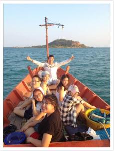 a group of people sitting on a boat in the water at Sattahiptale Boutique Guesthouse & Hostel in Sattahip