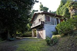 an old stone house with a balcony on a yard at Villa Scagliola in Verbania