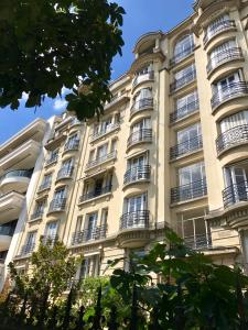 ヌイイ・シュル・セーヌにあるAppartement Neuilly sur Seine Paris Besson Stayのバルコニー付きの高い白い建物