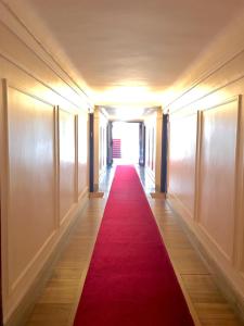 ヌイイ・シュル・セーヌにあるAppartement Neuilly sur Seine Paris Besson Stayの赤い絨毯が敷かれた長い廊下