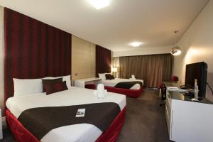 a hotel room with two beds and a television at City Golf Club Motel in Toowoomba