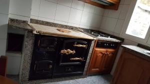 una vieja estufa negra en una cocina en Casa de Forno, en Queijadoiro