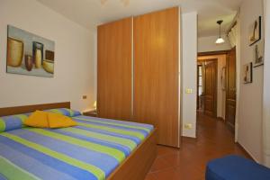a bedroom with a bed and a wooden cabinet at Casa Bel Giardino in Cannobio