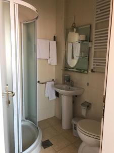 uma casa de banho com um chuveiro, um WC e um lavatório. em Hotel Satelit Kumanovo em Kumanovo
