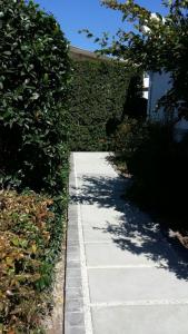 a sidewalk next to a building with a hedge at B's Place in Port Elizabeth