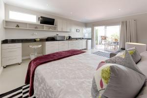 a bedroom with a large bed and a kitchen at B's Place in Port Elizabeth