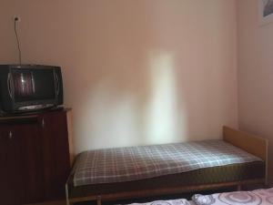 ハイドゥソボスローにあるTransilvania Apartmanのテレビ、ベッドが備わる小さな客室です。