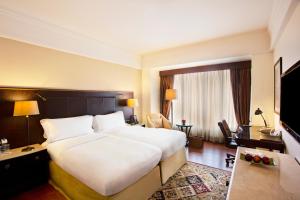 a hotel room with a large bed and a television at Eros Hotel New Delhi, Nehru Place in New Delhi