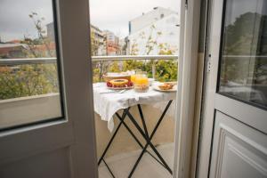 a table with food and drinks on a balcony at BCharming House in Porto
