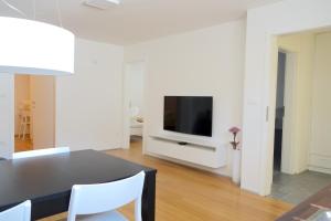 a living room with a dining table and a television at Sensei apartment in Ljubljana