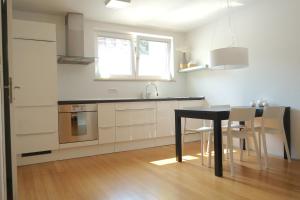 cocina con mesa negra y sillas en una habitación en Sensei apartment, en Liubliana