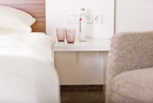 ein Schlafzimmer mit einem Bett, einem Tisch und einem Stuhl in der Unterkunft Restaurant Niedmühle Land & Genuss Hotel in Rehlingen-Siersburg