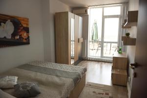 a small bedroom with a bed and a large window at Apartament Belvedere in Cluj-Napoca