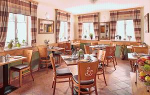 a restaurant with tables and chairs and windows at Pension Kasper in Vienna