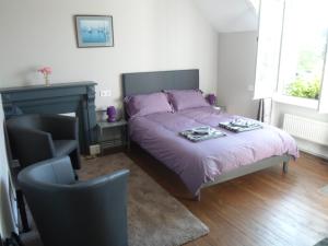 Un dormitorio con una cama con sábanas moradas y una silla en Riverside Bed and Breakfast, en Huelgoat