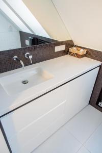 a bathroom with a white sink and a mirror at Apartament Rewa in Rewa
