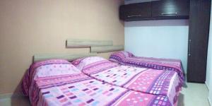 1 dormitorio con 2 camas con sábanas rosas en Joe Ann Apartments, en San Julián