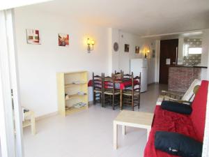 ein Wohnzimmer mit einem roten Sofa und einem Tisch in der Unterkunft Apartament Medes Parc I 4 6 inmoestartit in L'Estartit