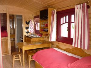 een slaapkamer met een bureau en een bed in een kamer bij La Roulotte des Matis in Cheux