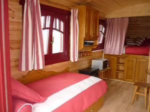 um quarto com uma cama num chalé de madeira em La Roulotte des Matis em Cheux