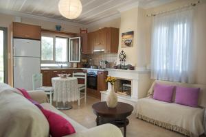 a living room with a couch and a kitchen at Lefkada Summer House in Nikiana