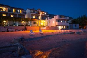 a beach with chairs and buildings at night at Seaside Luxury Suites in Podstrana
