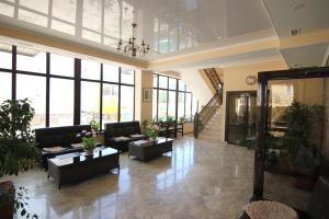 a large lobby with couches and tables and windows at Отель У рыбака in Bosteri