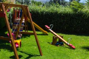 a group of playground equipment on the grass at Aria Villas - Private Pool, Playground, Ping Pong & Close to Beach, By ThinkVilla in Pigi