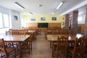 una clase con mesas y sillas de madera y una pizarra en Albergue de Sabero, en Sabero