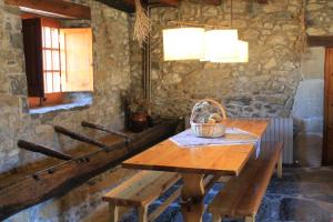 a table with a basket and benches in a room at Mas la Serra in Rupit